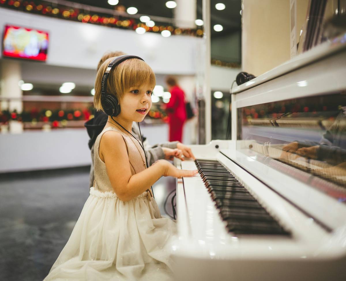 suzuki method piano lesson beginner benefit showing child playing piano with parent nearby
