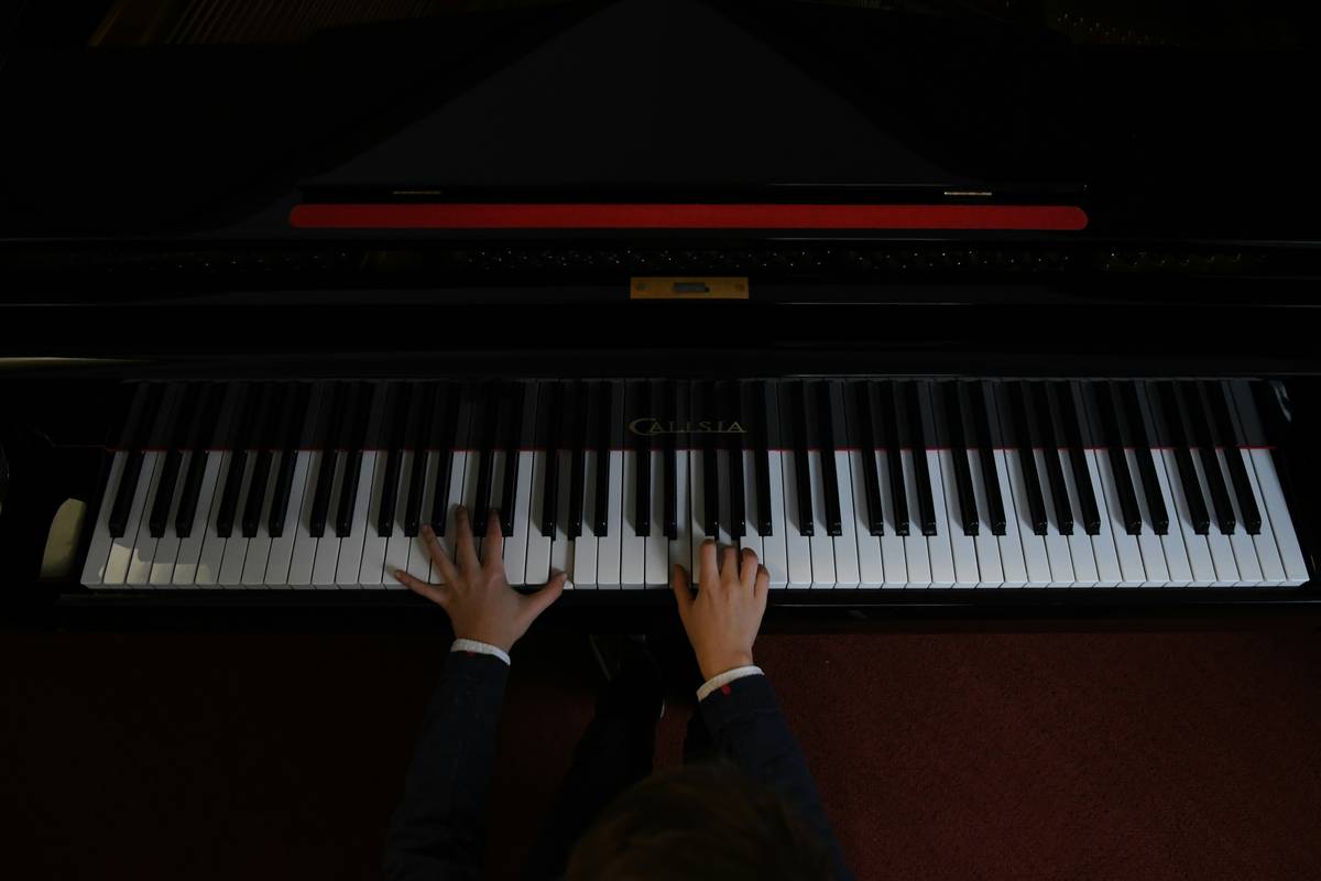 Beginner pianist following a structured piano practice routine for beginners with timer and sheet music